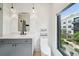 Bright bathroom featuring a gray vanity, modern lighting, and a large window, creating a fresh and clean aesthetic at 71 Krog Ne St, Atlanta, GA 30307