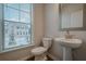 Modern bathroom includes toilet, pedestal sink, and exterior view through window at 123 Matson Sw Run, Mableton, GA 30126