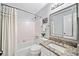 Bright bathroom with a granite countertop, white tile, and a shower-tub combo at 2166 Carlyle Dr, Marietta, GA 30062
