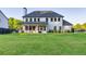 Expansive backyard featuring a well-manicured lawn, a covered patio, and a charming white house at 2381 Jones Phillips Rd, Dacula, GA 30019