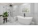 Elegant bathroom with a soaking tub, glass shower, marble floors, and modern fixtures at 2381 Jones Phillips Rd, Dacula, GA 30019