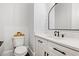Modern half bathroom showcasing white cabinets, marble countertops, a black arched mirror and modern fixtures at 2381 Jones Phillips Rd, Dacula, GA 30019