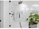 Modern shower with tiled walls, new shower hardware, and a glass door with plant accents at 2381 Jones Phillips Rd, Dacula, GA 30019