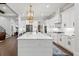 Bright, open kitchen with white cabinetry, marble countertops, and a decorative gold light fixture at 2381 Jones Phillips Rd, Dacula, GA 30019