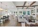 Open-concept living room with hardwood floors, beamed ceiling, and views of the backyard at 2381 Jones Phillips Rd, Dacula, GA 30019