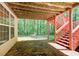 Covered back patio with a stone floor, staircase, and a peaceful view of the wooded backyard at 245 Ashley Forest Dr, Fayetteville, GA 30214