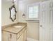 Bathroom features a sink with granite countertop, decorative mirror, and white cabinets at 245 Ashley Forest Dr, Fayetteville, GA 30214