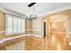 Formal dining room with hardwood floors, crown molding, large windows, and a decorative chandelier at 245 Ashley Forest Dr, Fayetteville, GA 30214