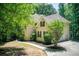 Side view of a well-manicured two-story home with an attached garage and a winding walkway at 245 Ashley Forest Dr, Fayetteville, GA 30214
