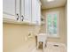 Bright laundry room with white cabinets, utility sink, and a window with plantation shutters at 245 Ashley Forest Dr, Fayetteville, GA 30214