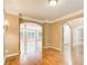 Open-concept living room featuring hardwood floors, arched doorways, and seamless flow into adjacent spaces at 245 Ashley Forest Dr, Fayetteville, GA 30214