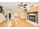 Spacious living room with hardwood floors, fireplace, ceiling fan, and staircase at 245 Ashley Forest Dr, Fayetteville, GA 30214