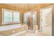 Luxurious main bathroom featuring a soaking tub, glass enclosed shower, and neutral tile at 245 Ashley Forest Dr, Fayetteville, GA 30214