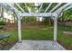 Lush backyard featuring a white pergola, a fire pit, mature trees, and a well-maintained lawn at 755 Waterbrook Ter, Roswell, GA 30076