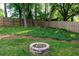 Charming backyard featuring a stone fire pit, well-maintained lawn, and a newly constructed wooden fence at 755 Waterbrook Ter, Roswell, GA 30076