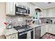 Well-lit kitchen with stainless steel appliances, granite countertops, and decorative tile backsplash at 755 Waterbrook Ter, Roswell, GA 30076