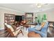 Cozy living room with a stone fireplace, ceiling fan, and large windows at 755 Waterbrook Ter, Roswell, GA 30076