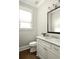 Elegant powder room with white vanity, marble countertop, and window at 775 A Harrison Se Pl, Atlanta, GA 30315
