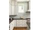 Close-up of a kitchen with white cabinets, stone countertops, and a stylish backsplash at 775 A Harrison Se Pl, Atlanta, GA 30315