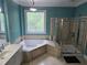 Bathroom featuring a soaking tub, glass shower and large decorative window for natural light at 1042 Emory Parc Pl, Decatur, GA 30033