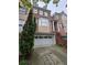 Charming brick townhouse with a two-car garage and landscaped front, offering both curb appeal and convenience at 1042 Emory Parc Pl, Decatur, GA 30033