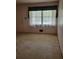 Vacant living room with a large window and neutral walls and carpet at 2137 Plantation Ln, Chamblee, GA 30341