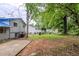 Large, grassy backyard featuring mature trees and a concrete patio at 2347 Fairway Sw Cir, Atlanta, GA 30331