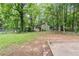 Grassy backyard with a home and a patio surrounded by mature trees at 2347 Fairway Sw Cir, Atlanta, GA 30331