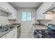 Well-lit kitchen with white cabinetry, granite countertops, and black appliances at 2347 Fairway Sw Cir, Atlanta, GA 30331