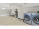 This is a basement laundry area with neutral carpet and newer appliances at 2840 Peachtree Nw Rd # 307, Atlanta, GA 30305