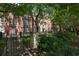 Apartment building exterior with lush trees, wrought iron fencing and a courtyard patio with outdoor seating at 2840 Peachtree Nw Rd # 307, Atlanta, GA 30305