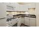 Kitchen featuring white cabinets, a black countertop, and modern appliances at 2840 Peachtree Nw Rd # 307, Atlanta, GA 30305