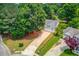 Aerial view of a home with a long driveway surrounded by mature trees and landscaping at 627 New England Way, Lawrenceville, GA 30046