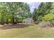 A large yard with mature trees surrounds the back of the home at 627 New England Way, Lawrenceville, GA 30046