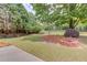 Spacious backyard with mature trees, a well-maintained lawn, and a brick planter at 627 New England Way, Lawrenceville, GA 30046