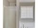 Close up of the shower and tub in a bathroom with gray walls and a window at 627 New England Way, Lawrenceville, GA 30046