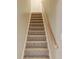 Carpeted stairway with wooden handrail leading to the upper level of the home at 627 New England Way, Lawrenceville, GA 30046