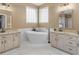This bathroom includes double vanities, granite countertops, bright mirrors, a soaking tub and modern finishes at 1466 Lake Forest Ln, Mcdonough, GA 30253
