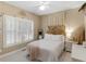 Bright bedroom with white shutters, wooden headboard, and soft, neutral decor at 1466 Lake Forest Ln, Mcdonough, GA 30253
