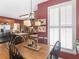 This dining room features a wooden table set with decor, hanging lighting, and views of the kitchen and a bright window at 1466 Lake Forest Ln, Mcdonough, GA 30253