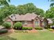 Well-maintained brick home showcasing lush landscaping and a beautifully manicured lawn at 1466 Lake Forest Ln, Mcdonough, GA 30253