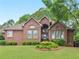 Charming brick home featuring manicured lawn, mature trees, and covered front entrance at 1466 Lake Forest Ln, Mcdonough, GA 30253