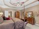 This main bedroom offers a tray ceiling, a four post bed with decorative pillows and furniture for plenty of storage at 1466 Lake Forest Ln, Mcdonough, GA 30253