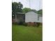 View of the home's exterior, featuring a covered patio and grassy lawn area at 4253 Hanes Dr, Decatur, GA 30035
