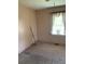A view of an empty bedroom featuring carpet, baseboard and window at 4253 Hanes Dr, Decatur, GA 30035