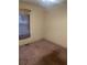 A view of an empty bedroom featuring carpet, baseboard and window at 4253 Hanes Dr, Decatur, GA 30035