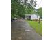 Quaint one-story home with a long driveway and mature trees on a grassy lawn at 4253 Hanes Dr, Decatur, GA 30035