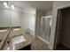 Bathroom featuring double sinks, granite countertops, and a glass shower at 6474 Grey Fox Way, Riverdale, GA 30296