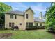 Back exterior showcasing backyard with mature trees and grill on patio at 6895 Old Fox Trl, Stone Mountain, GA 30087