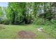 Backyard featuring mature trees and a wooded backdrop at 6895 Old Fox Trl, Stone Mountain, GA 30087
